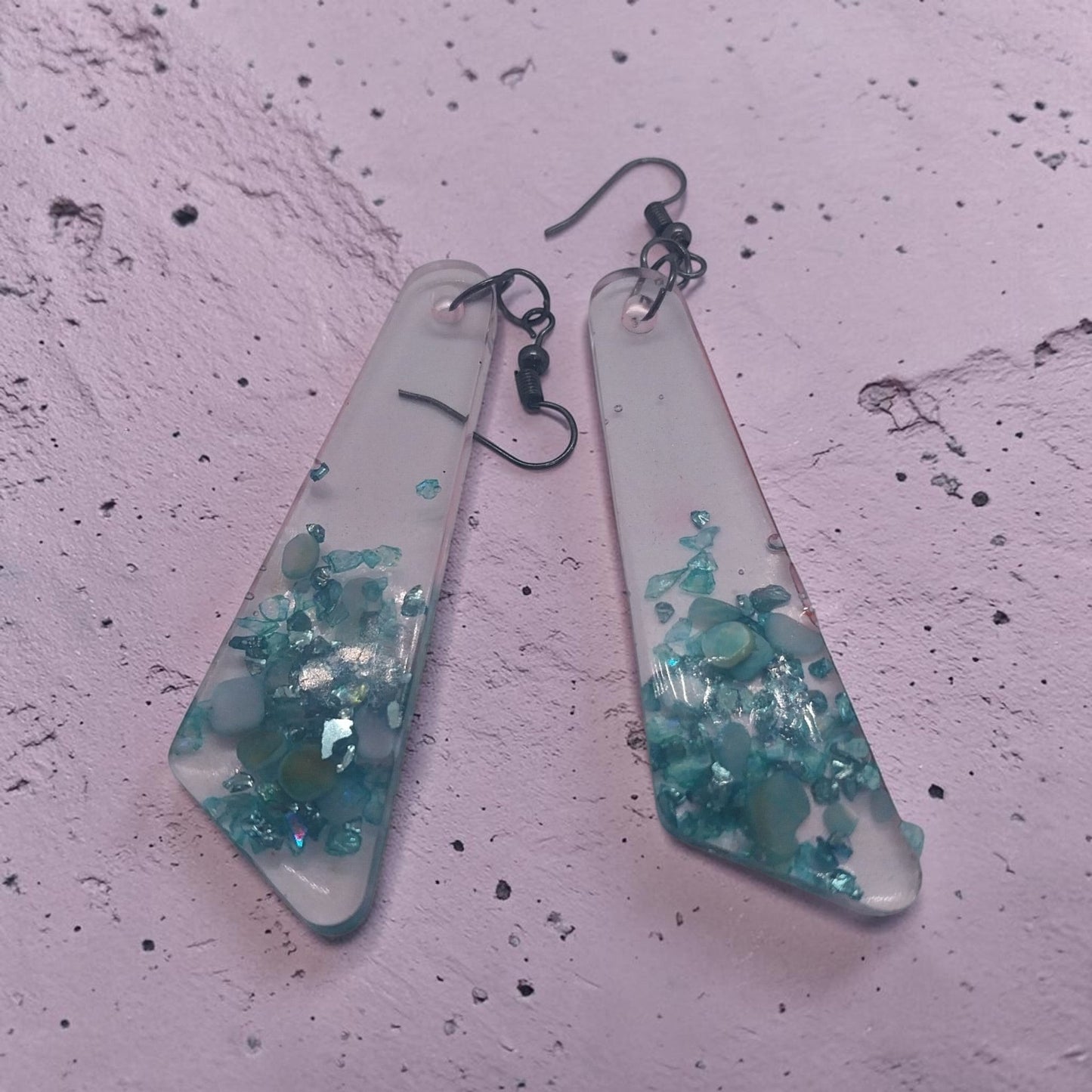 Artymunk3y geometric resin dangle earrings with translucent frosted finish and embedded teal turquoise stone chips.