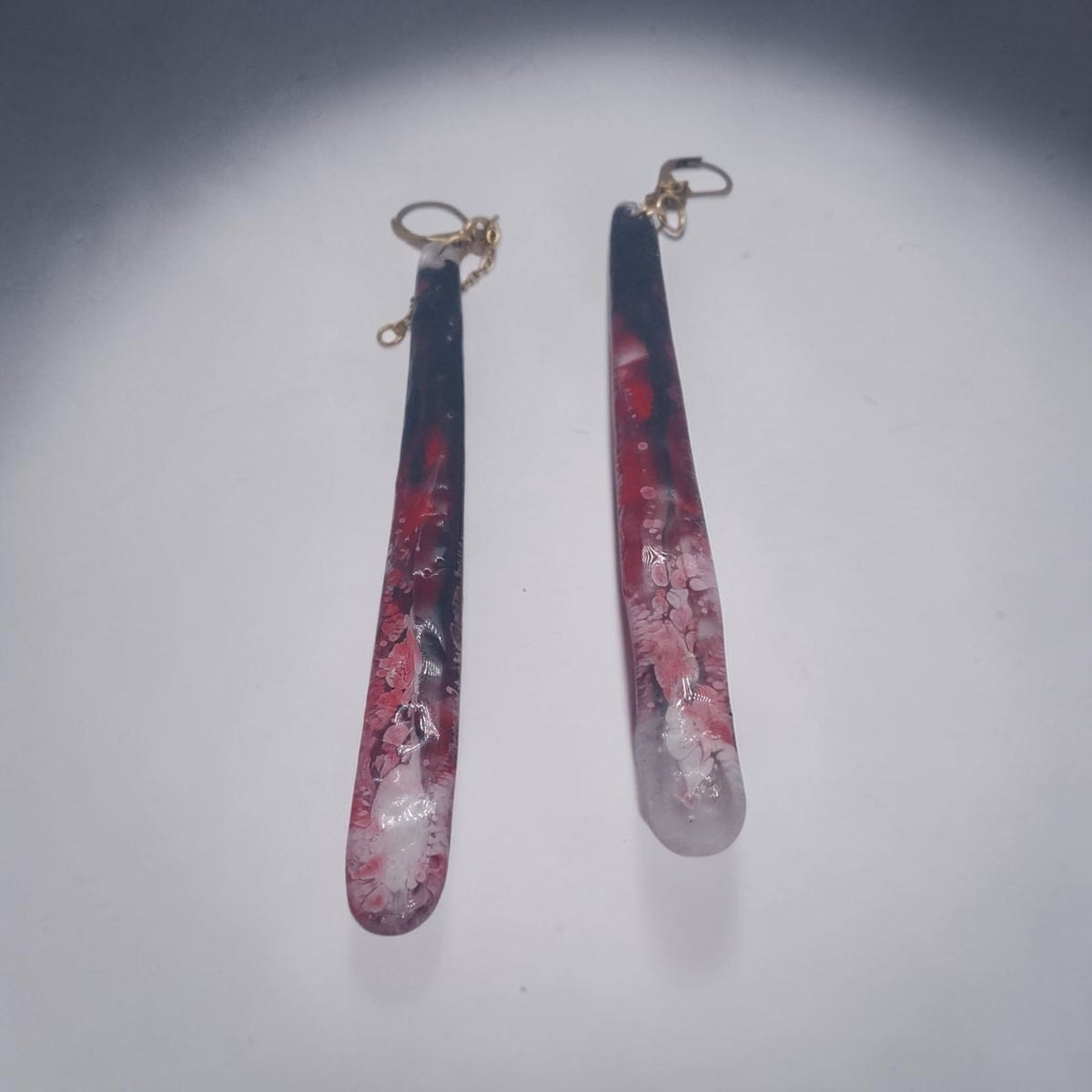 Artymunk3y long resin drop earrings with marbled black, crimson, and white swirls and gold-toned hardware.