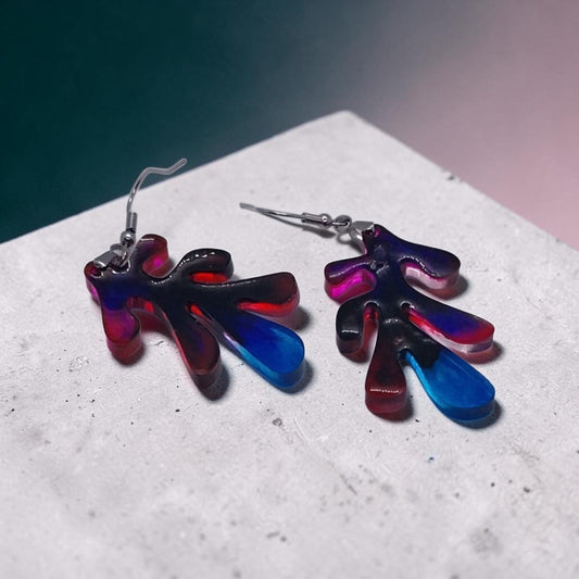 Artymunk3y abstract resin drop earrings with organic leaf shapes in a red, blue, and violet gradient on a stone base.