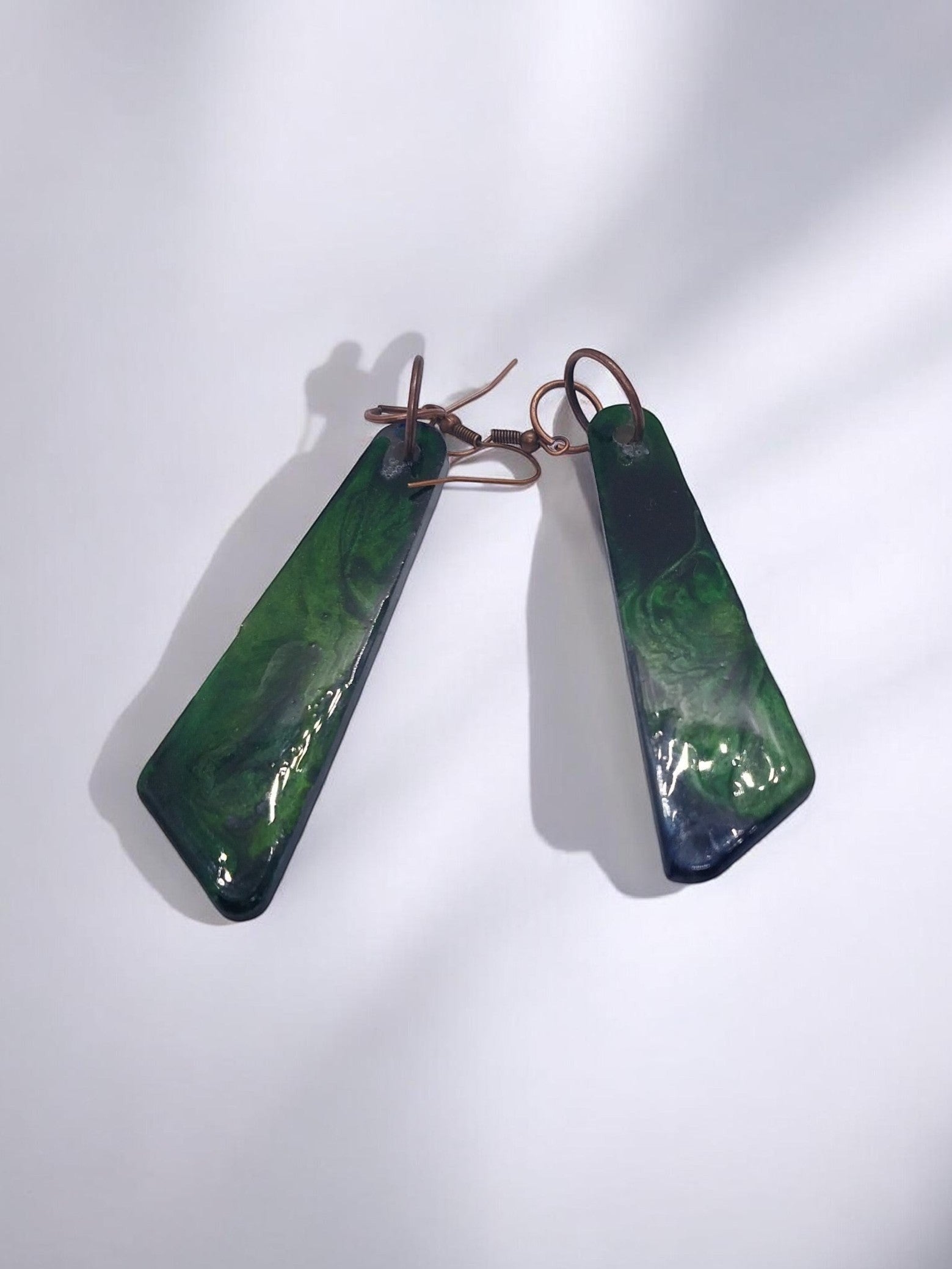 Artymunk3y abstract swirl dangle earrings in deep green with glossy finish and copper ear wires.