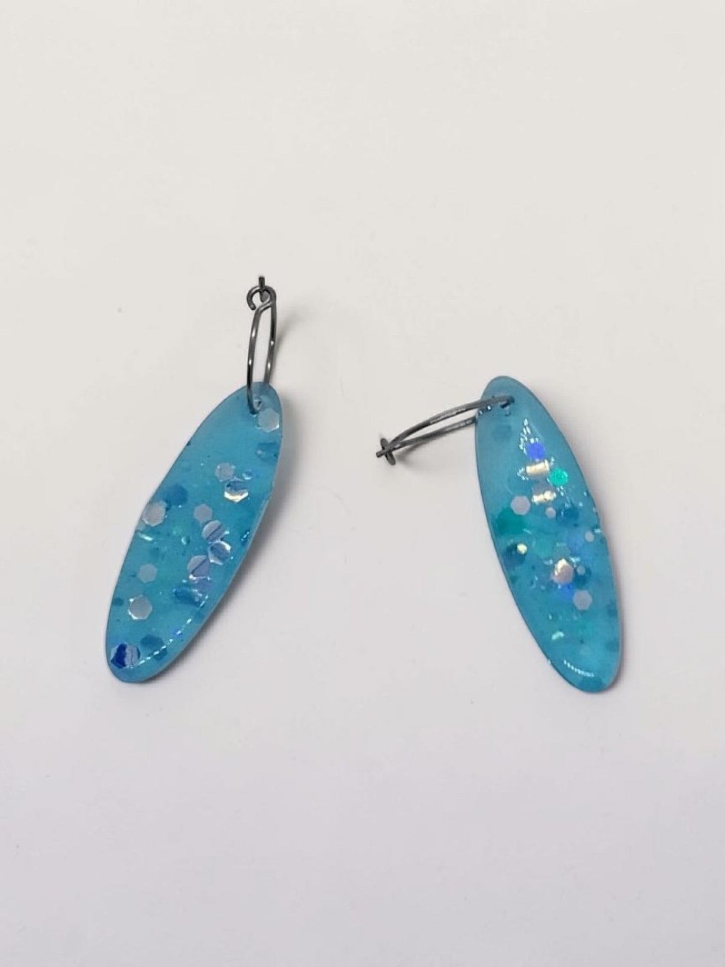 Artymunk3y sky blue oval resin dangle earrings with iridescent glitter and confetti.