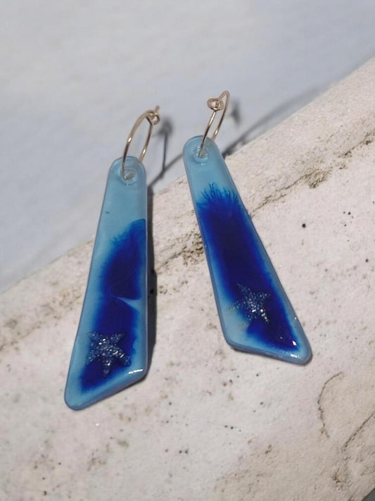 Artymunk3y blue resin drop earrings with glitter starfish charms and gold-toned hoops.
