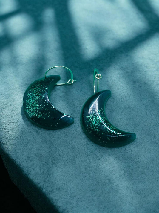 Artymunk3y dark green crescent moon dangle earrings with green glitter accents.