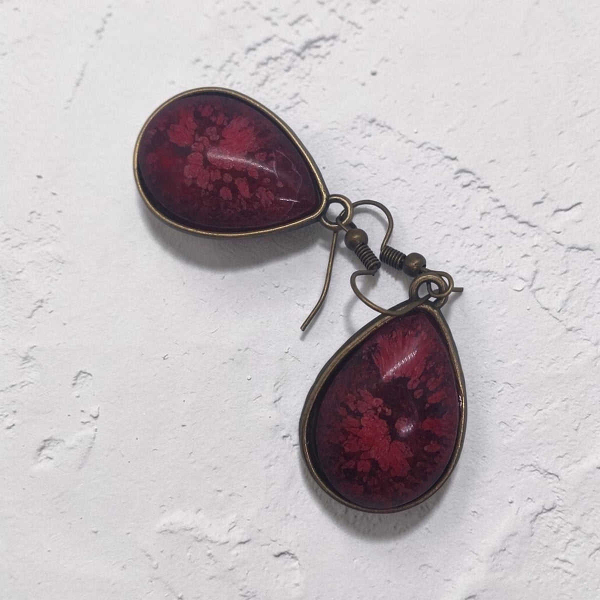 Artymunk3y teardrop dangle earrings featuring deep crimson resin with floral patterns in an antique-bronze setting.