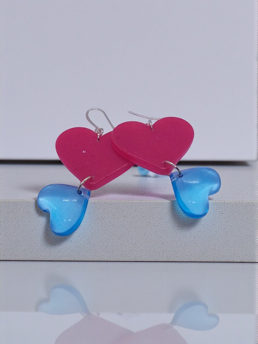 Artymunk3y Double Heart Dangle Earrings in pink and translucent blue resin with silver hooks.