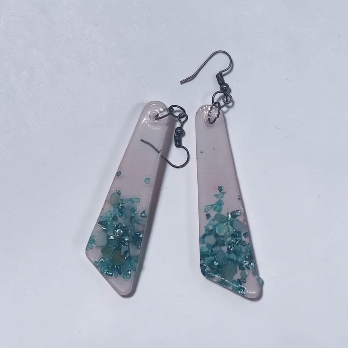 Artymunk3y geometric resin dangle earrings with translucent frosted finish and embedded teal turquoise stone chips.