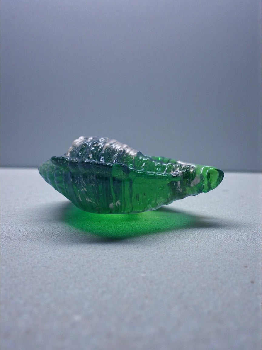 Artymunk3y green glass seashell sculpture ornament with silver accents, detailed texture.
