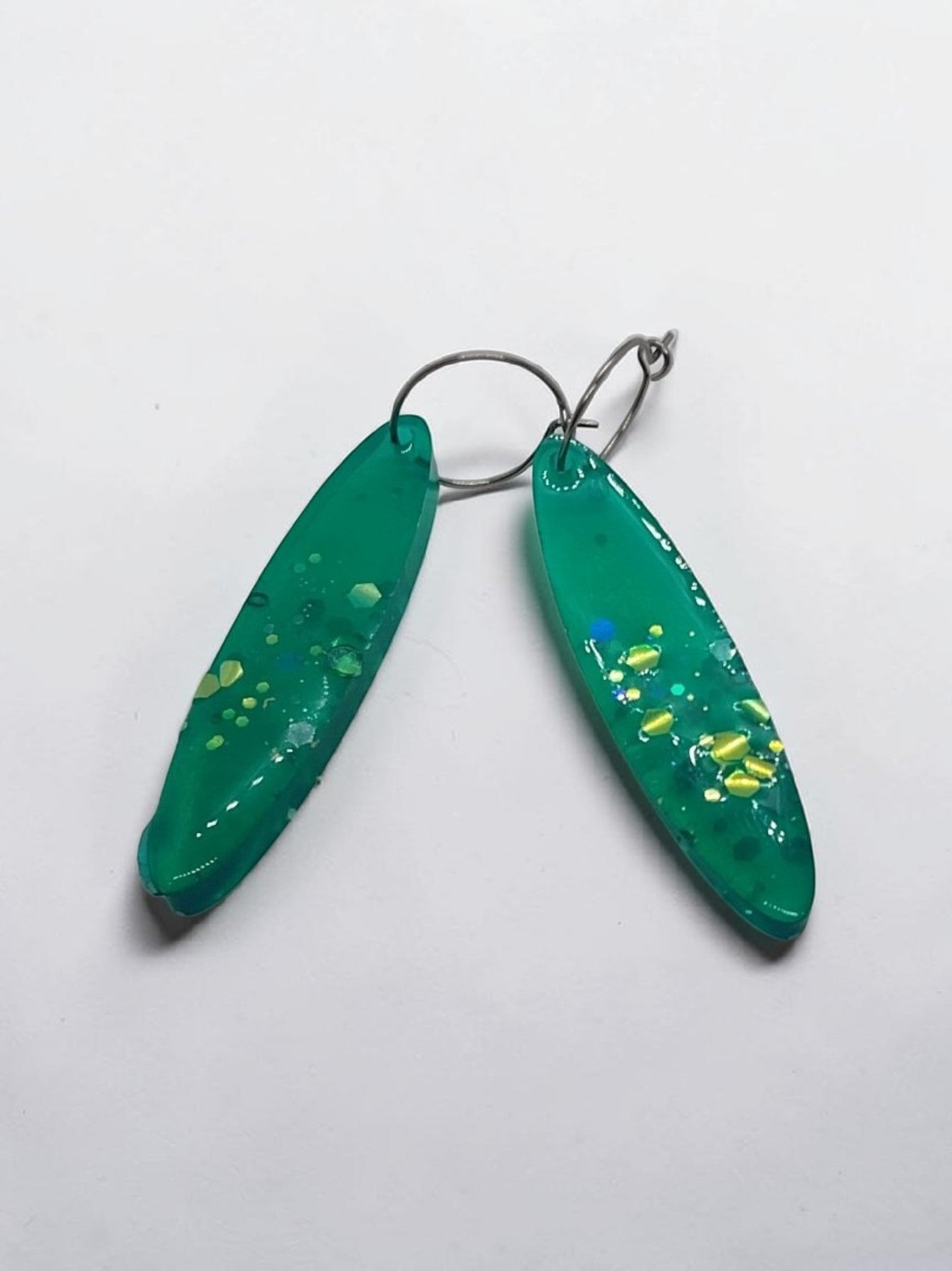 Artymunk3y green resin teardrop earrings with gold, yellow, and blue glitter accents. Lightweight and elegant.