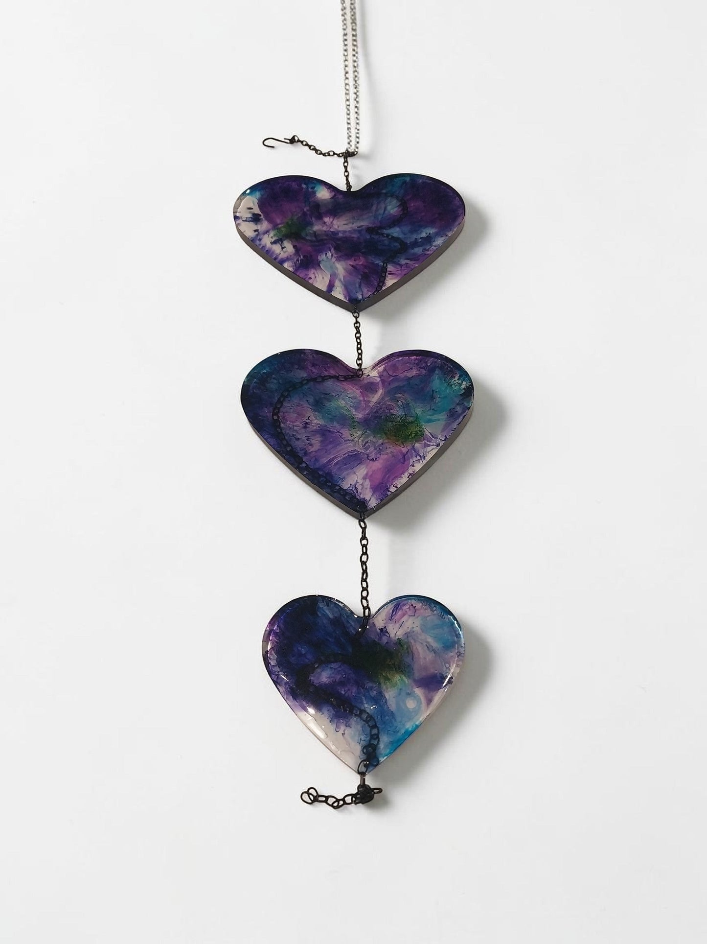 Artymunk3y hanging heart resin wall art decoration with purple, blue, and green galaxy-like patterns.