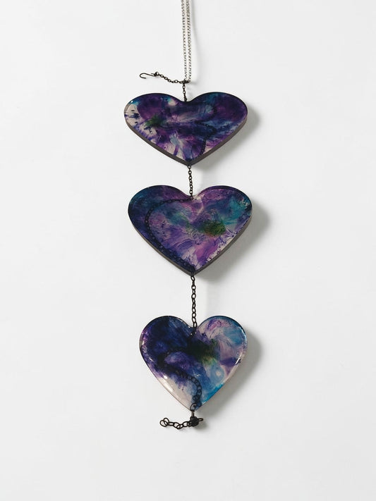 Artymunk3y hanging heart resin wall art decoration with purple, blue, and green galaxy-like patterns.