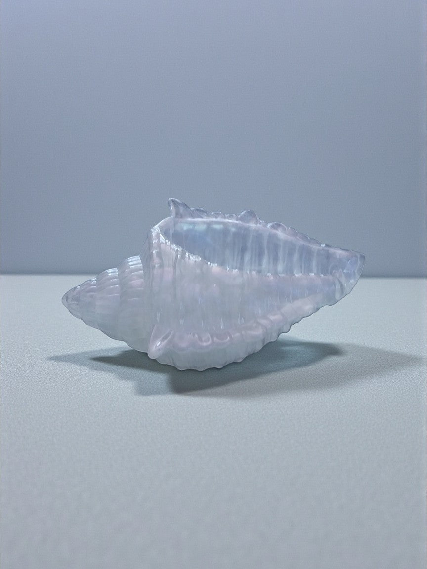Artymunk3y iridescent glass seashell decorative object with pearlescent sheen and subtle blue and pink hues.