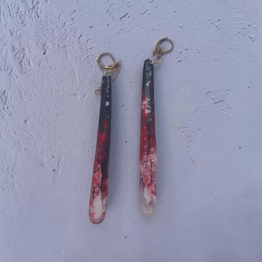 Artymunk3y long resin drop earrings featuring marbled black, crimson, and white swirls with gold-toned hardware.