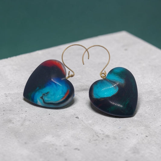 Artymunk3y handcrafted resin heart drop earrings with a marbled midnight blue, turquoise, and crimson red finish.