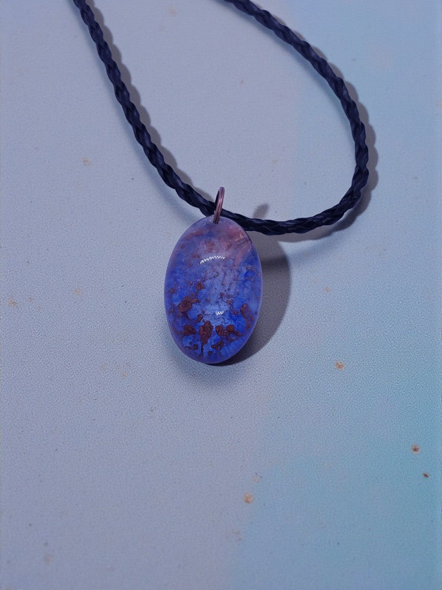 Artymunk3y oval pendant necklace with blue and purple marbled stone and braided black cord.