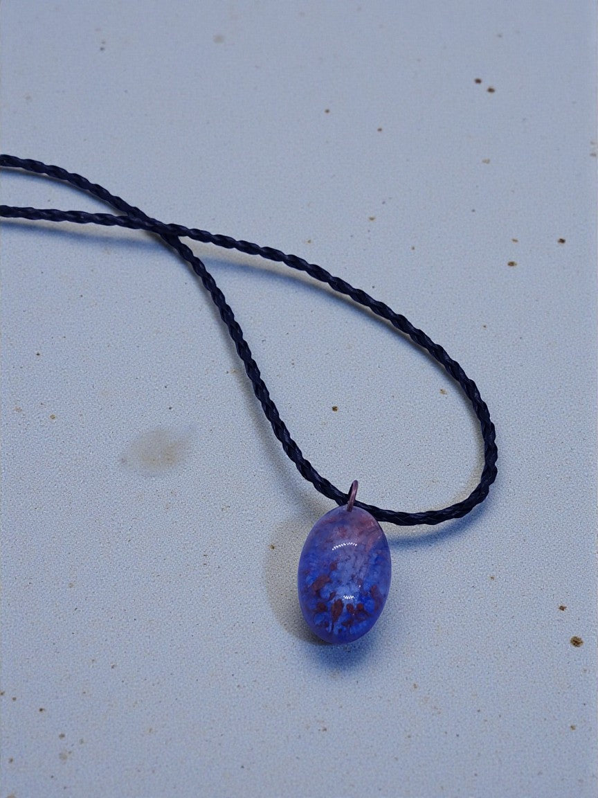 Artymunk3y oval pendant necklace with blue and purple marbled stone on braided black cord.