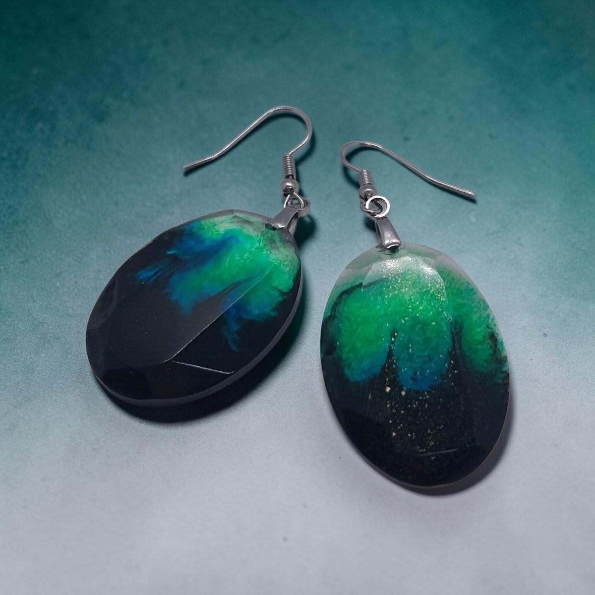 Artymunk3y handcrafted oval resin drop earrings in black, emerald green, and teal with silver-toned hooks.
