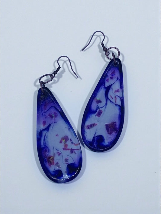 Artymunk3y teardrop resin dangle earrings with purple and white swirls and embedded inclusions. Antiqued copper hooks.