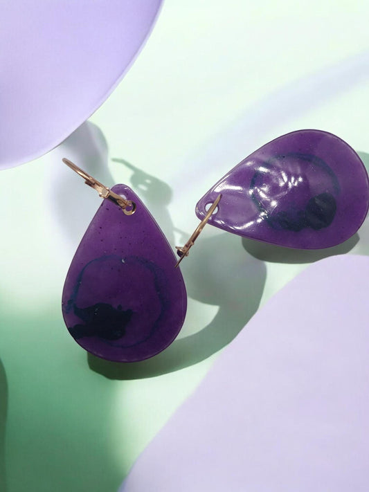 Artymunk3y purple resin teardrop dangle earrings with blue and black swirls, gold leverback closures.