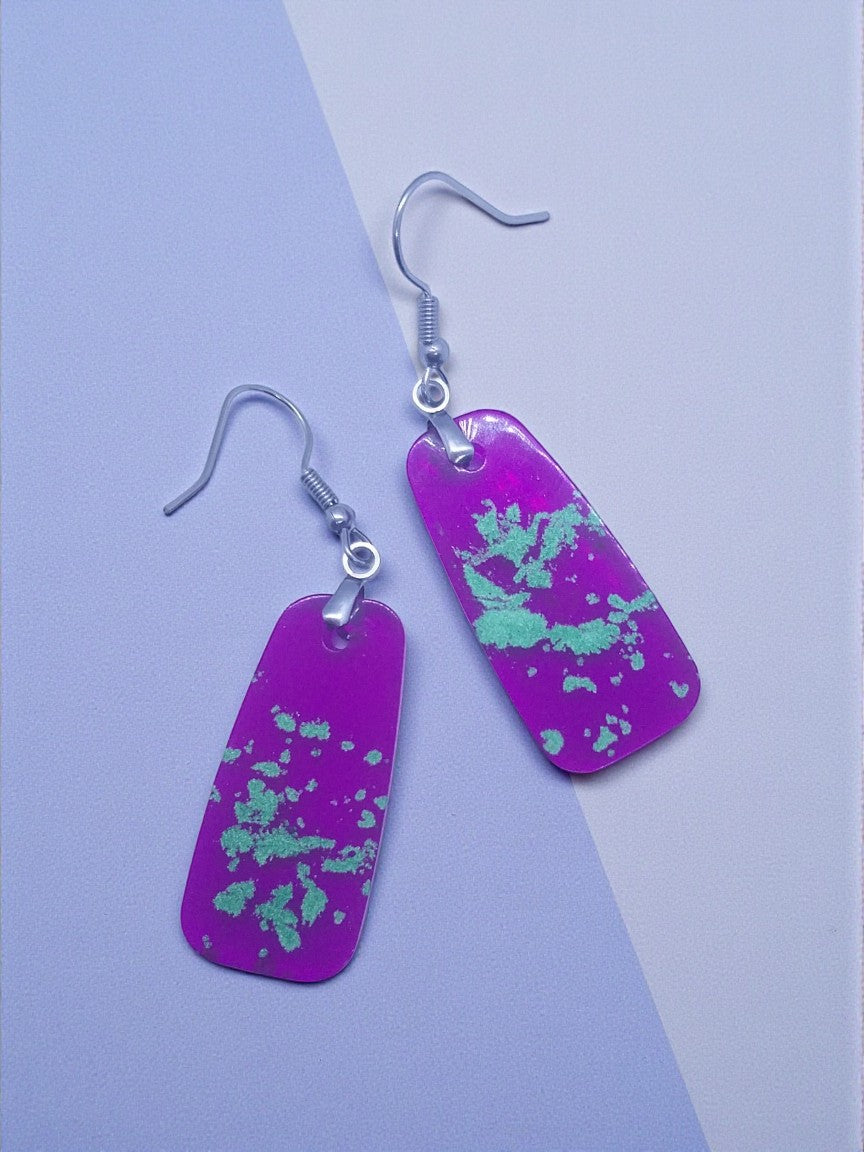 Artymunk3y purple rectangular dangle earrings with light green speckled pattern and silver-toned fishhook ear wires.