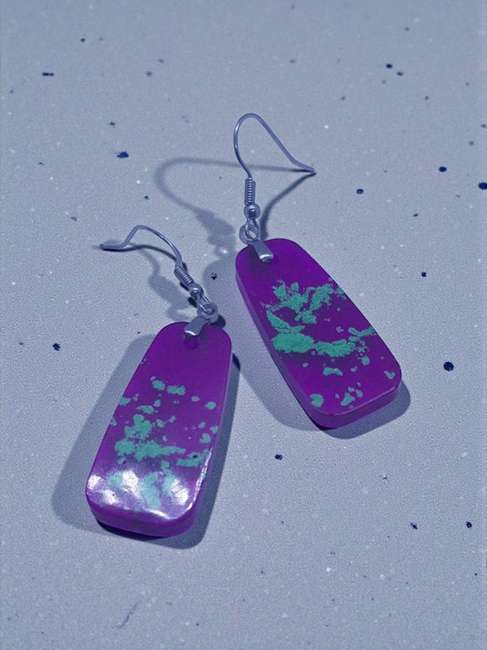 Artymunk3y purple rectangular dangle earrings with light green speckled pattern and silver-toned fishhook ear wires.