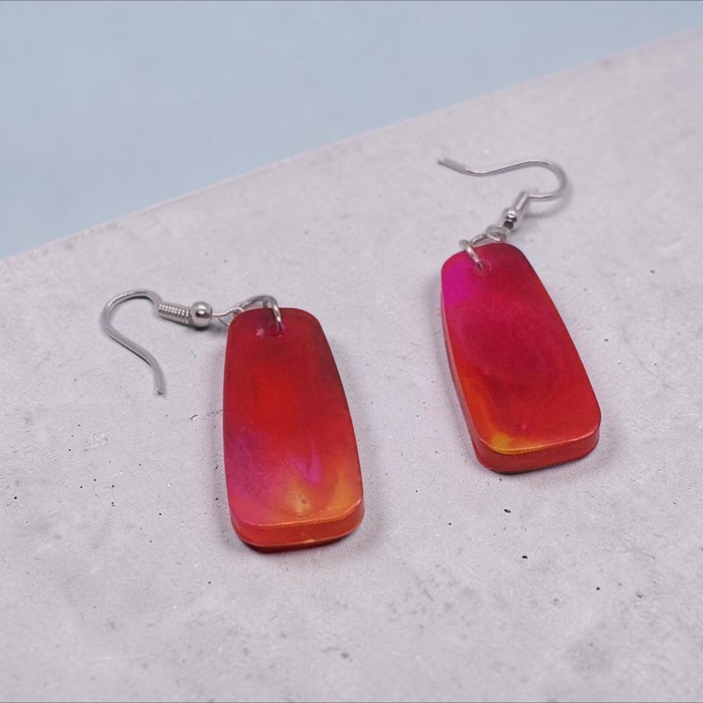 Artymunk3y rectangular resin drop earrings featuring a marbled sunset palette of red, orange, and pink with silver hooks