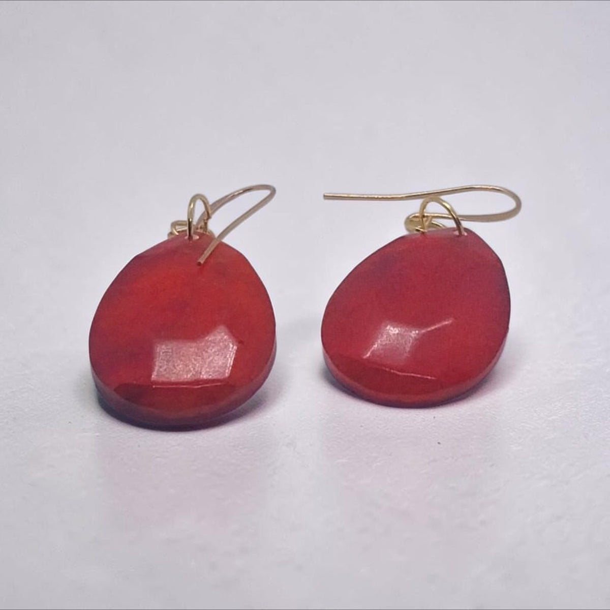 Artymunk3y faceted red teardrop dangle earrings with gold-tone hooks on a white background