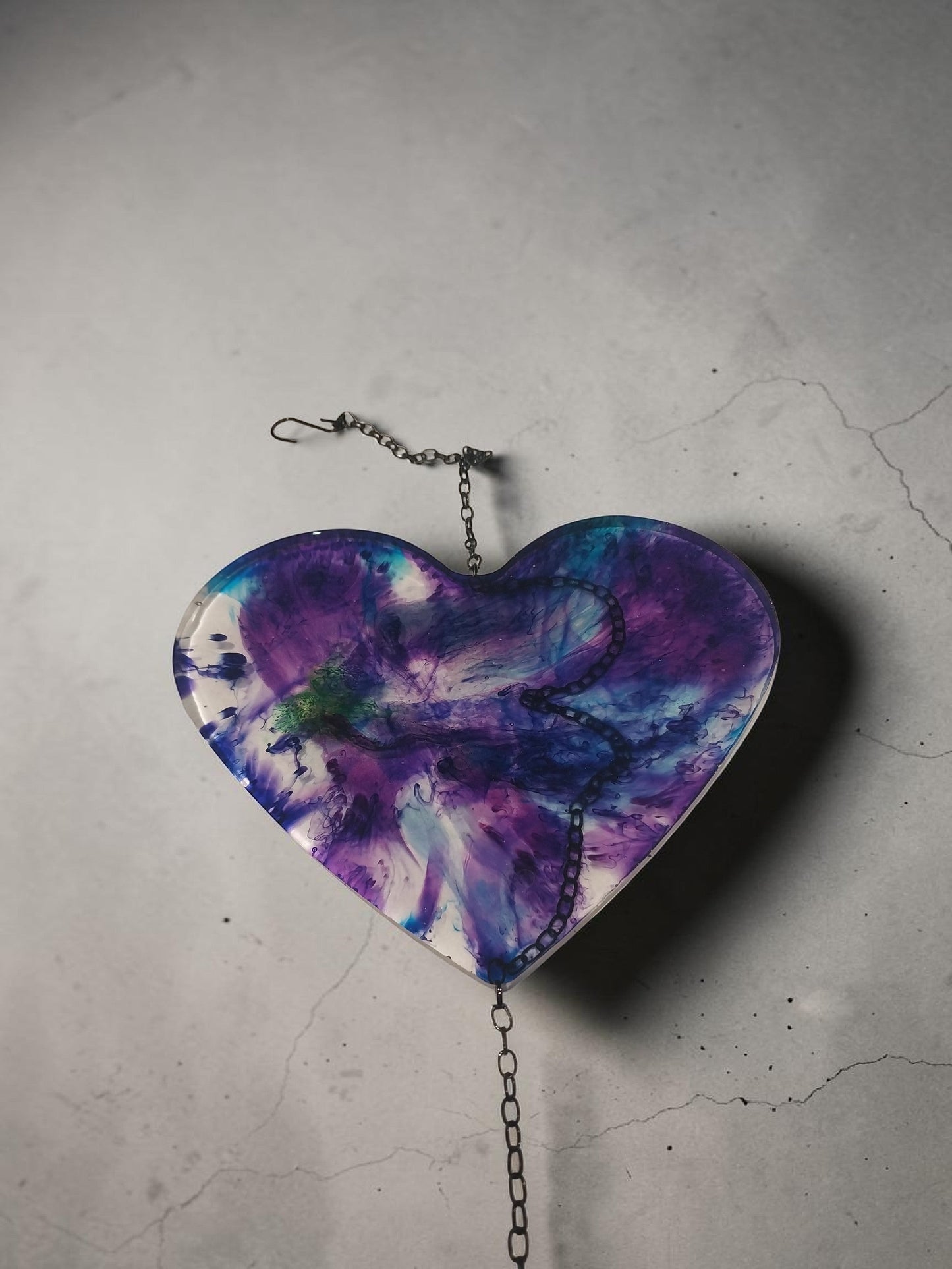Artymunk3y resin heart wall art with purple, blue, and green galaxy swirls, suspended by a metal chain.