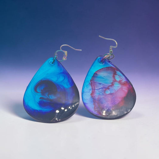 Artymunk3y handcrafted resin teardrop dangle earrings with a galaxy-like swirl of blue, purple, and pink colours.