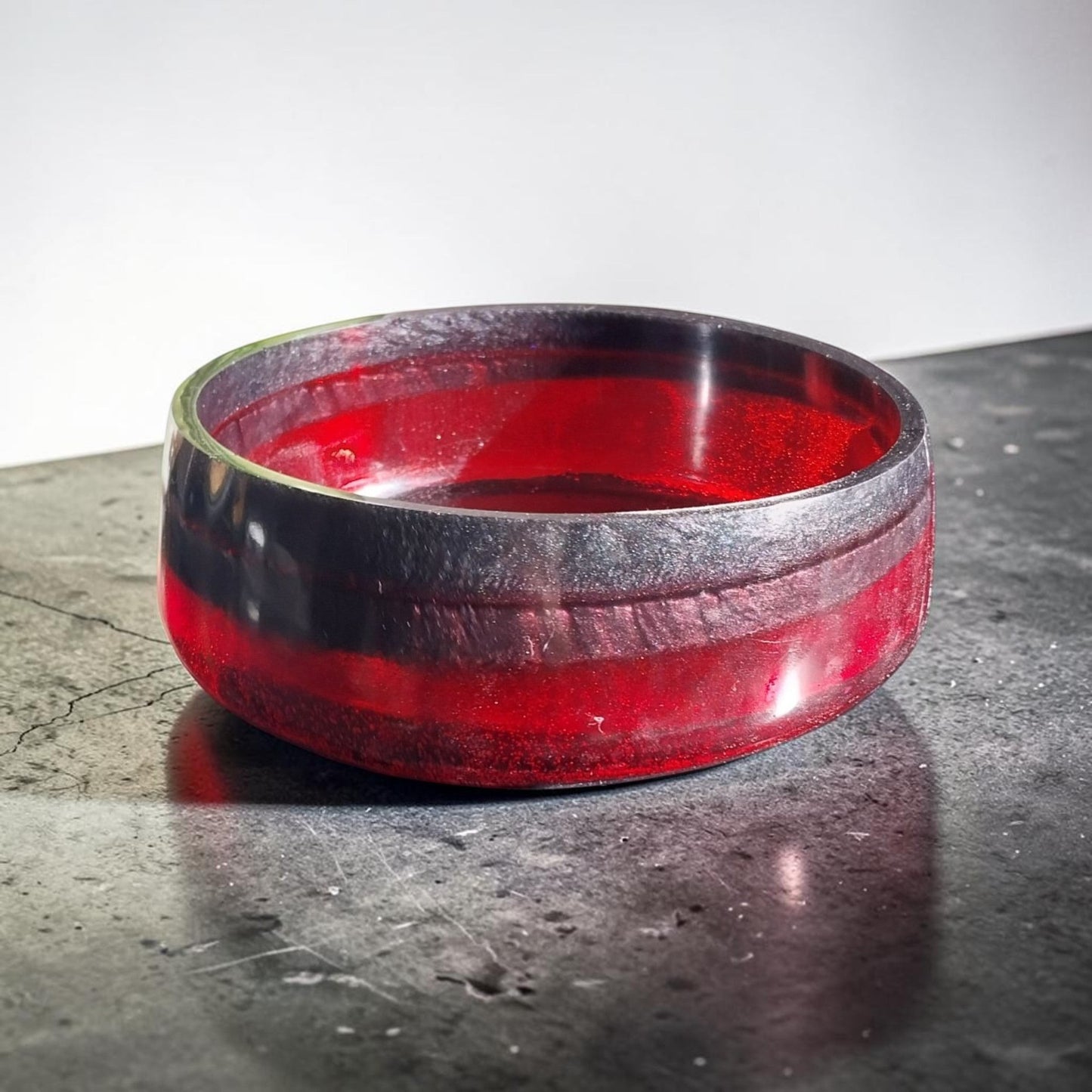 Artymunk3y handcrafted resin bowl in translucent ruby red and opaque black, featuring a smooth, polished finish.