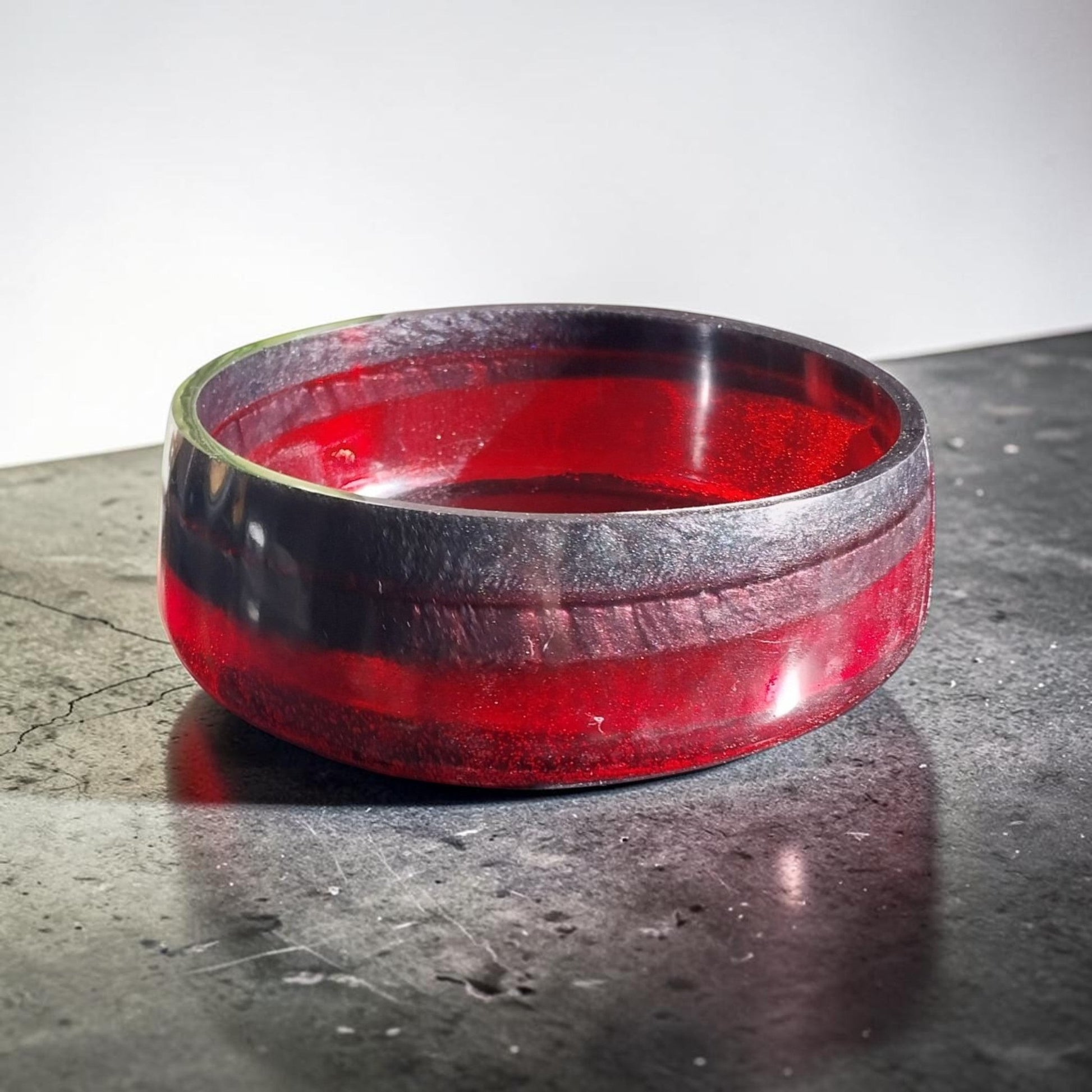 Artymunk3y handcrafted resin bowl in translucent ruby red and opaque black, featuring a smooth, polished finish.