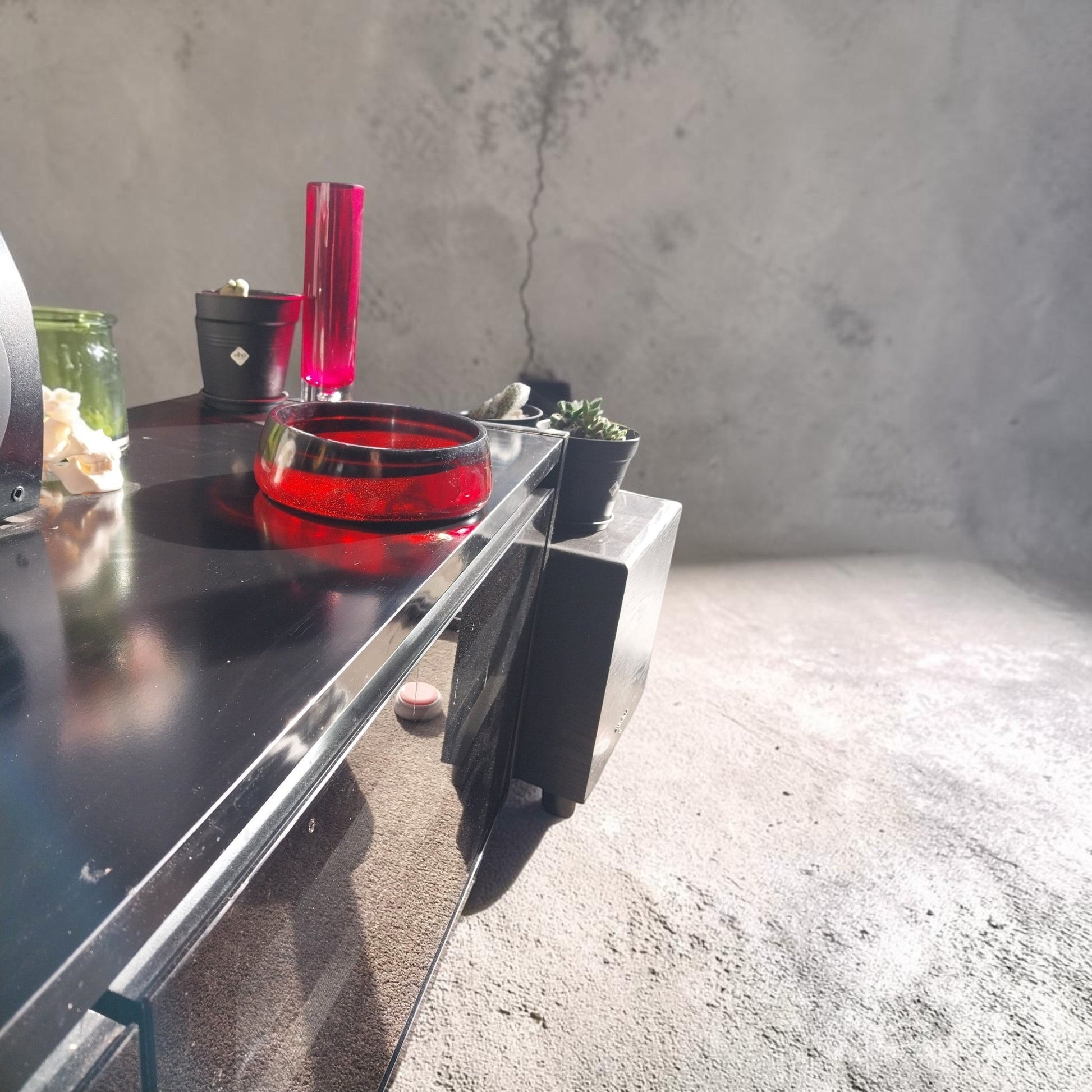 Artymunk3y handcrafted translucent ruby red resin bowl on a black console table with modern home decor accents.