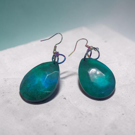 Artymunk3y teardrop dangle earrings in faceted teal and emerald resin with iridescent oil-slick metal hooks.