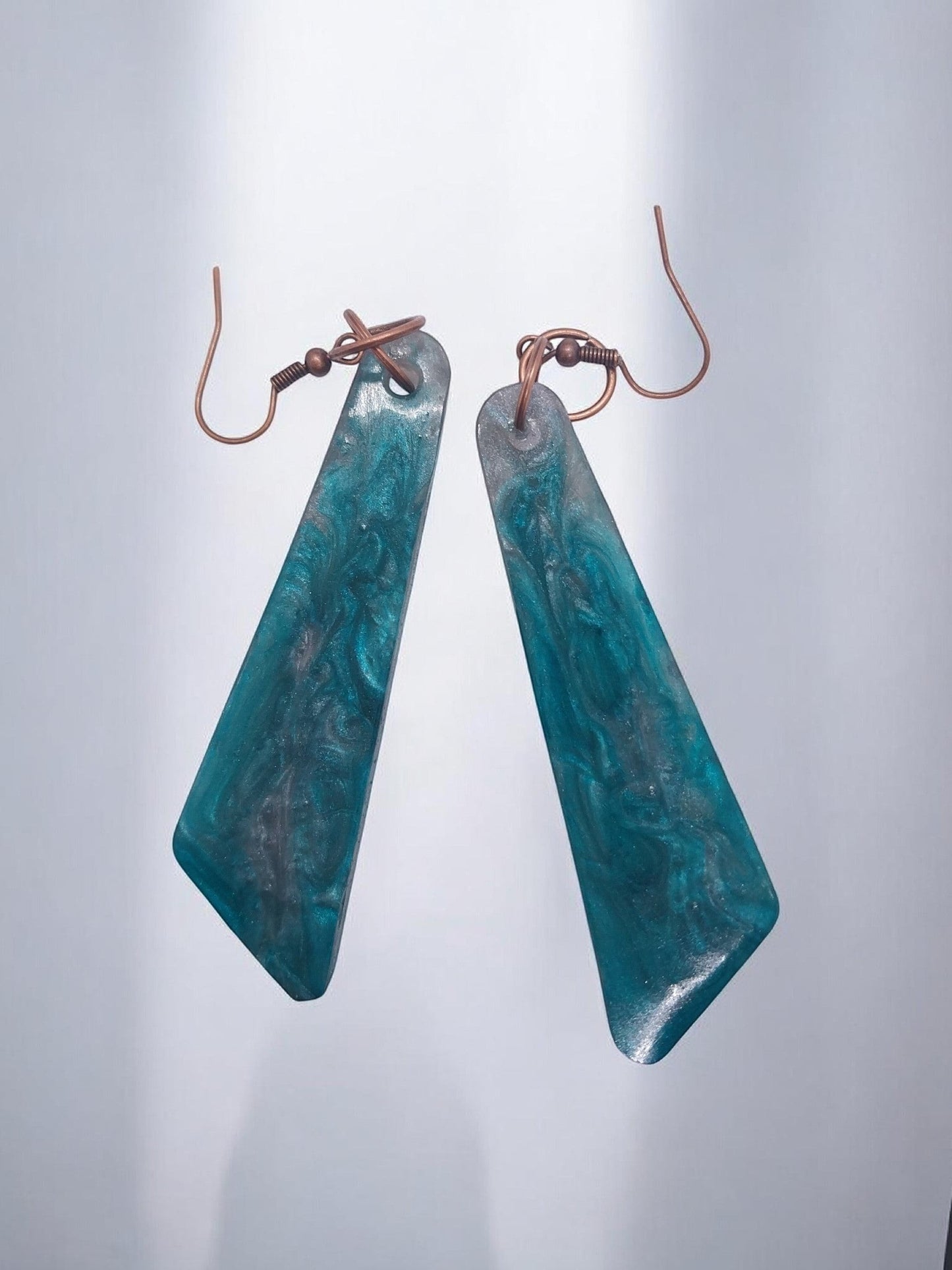 Artymunk3y Teal Swirl Resin Drop Earrings with geometric shape and copper-toned ear wires.